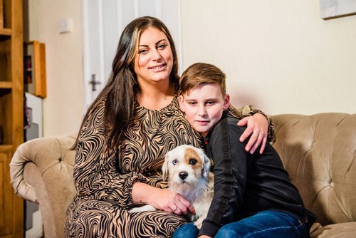 Freddie with his mum Stacy smiling with their family dog