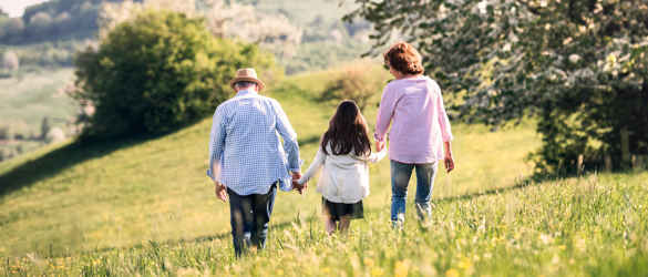 Grandparents walking with granddaughter in nature