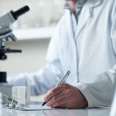 Scientist writing on a pad